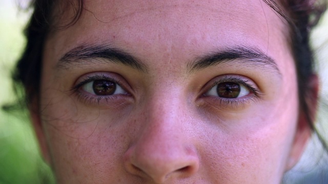 女人睁开眼睛的微距特写，凝视着户外的相机视频下载