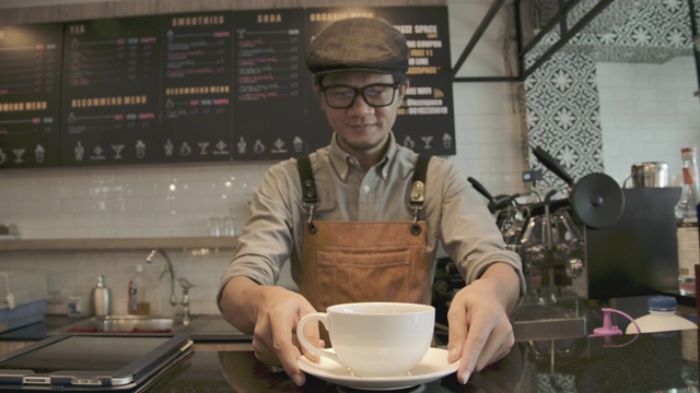 在咖啡店里为顾客服务的亚洲服务生。视频素材