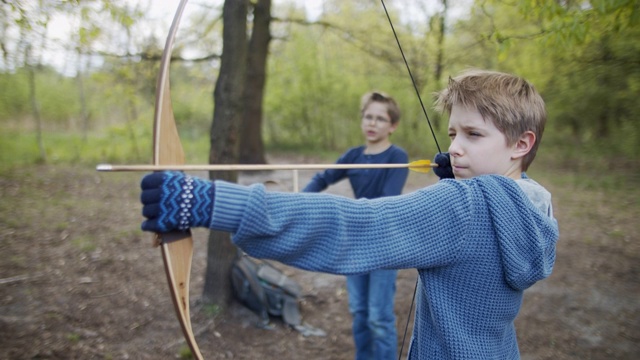 两个男孩在森林里用弓箭射击视频素材