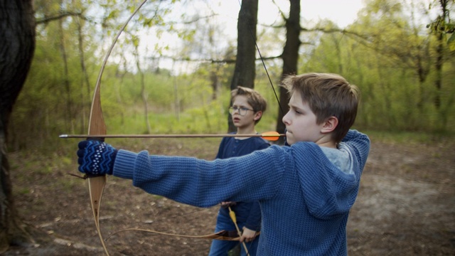 两个男孩在森林里用弓箭射击视频素材