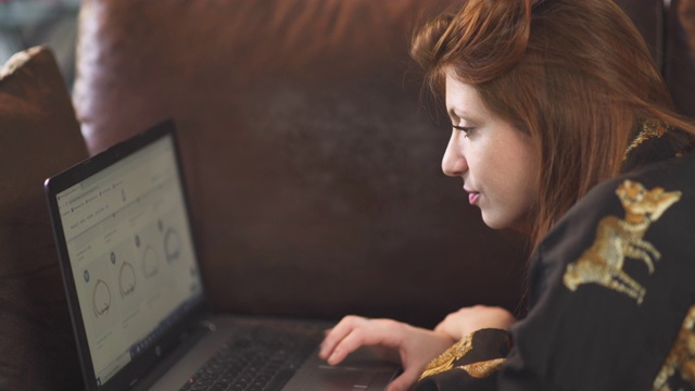 在法国covid-19大流行期间，一名白人妇女在家通过电脑在网上购物。一人年轻女孩孤立。在项目上工作。检疫期间购物。4 k UHD。视频下载