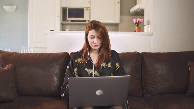 可爱的女人在家用电脑工作，在法国covid-19大流行期间在室内工作。一人年轻女孩孤立。敲击键盘。隔离期间远程工作静态的广角镜头。视频下载