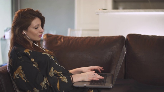 在法国covid-19大流行期间，有魅力的女人在家用电脑工作，在室内工作。4K超高清电视。一人年轻女孩孤立。敲击键盘。隔离期间远程工作视频下载