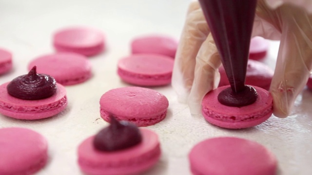 制作马卡龙的过程马卡龙，法式甜点，挤压面团形成烹饪袋视频素材