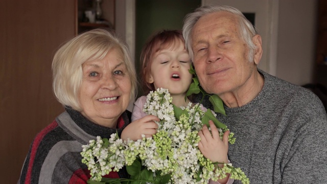 孙女和奶奶在家里亲吻微笑的爷爷视频素材