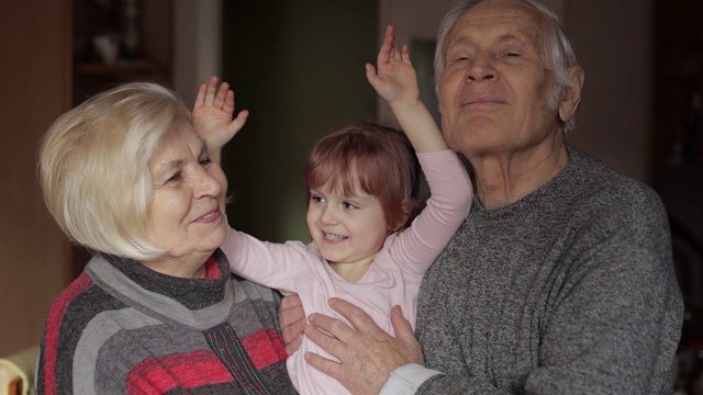家人爷爷面带微笑，奶奶带着孩子孙女在家视频素材