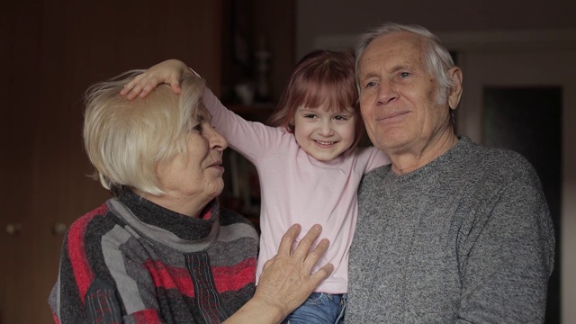家人爷爷面带微笑，奶奶带着孩子孙女在家视频素材
