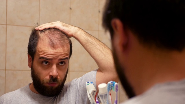浴室镜子里的男人有脱发问题视频下载