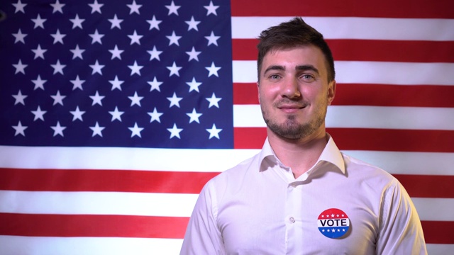 一名男子微笑着在美国国旗的背景上题写着“博伊特”。总统选举的概念。视频下载
