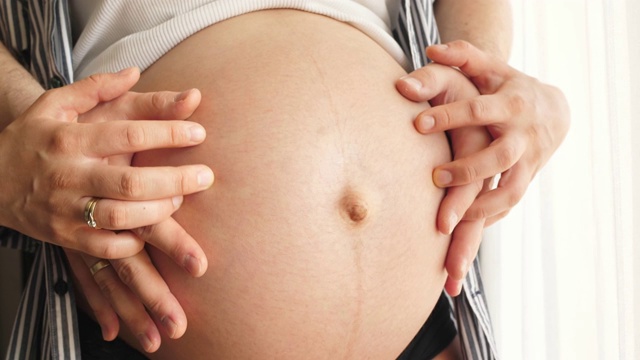 父母用手触摸孕妇的肚子视频素材