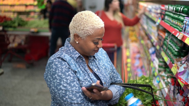 女人用手机在超市购物的肖像视频素材