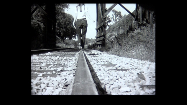 1968年，年轻的女士赤脚走在铁轨上视频素材