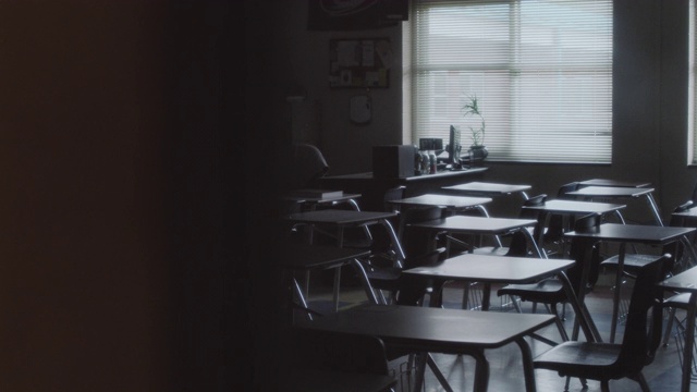 横向跟踪拍摄了一间空教室满是空课桌。视频素材
