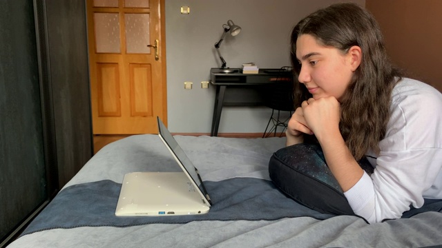 年轻女孩在家通过电脑观看在线课程，在家上学，4K视频素材