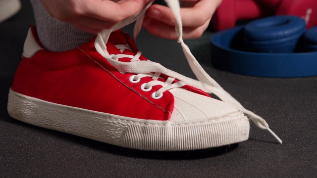 一个女人在训练前将鞋带系在运动鞋上视频下载
