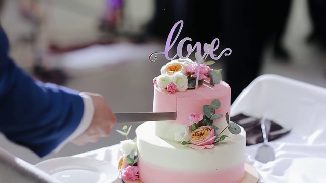 新婚夫妇切结婚蛋糕。相爱的情侣一起切婚礼的甜蜜蛋糕。一位新娘和一位新郎正在切他们的结婚蛋糕。新娘和新郎的手切下一片婚礼蛋糕。视频素材