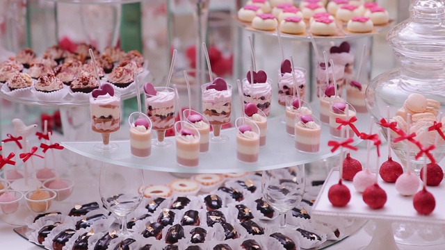美味的婚宴糖果吧甜品桌上的庆祝大厅。婚礼糕点的甜桌上糖果自助餐视频素材
