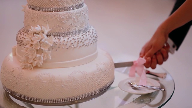 婚礼蛋糕。宴会上的传统庆祝甜点。新娘和新郎剪一块。视频素材