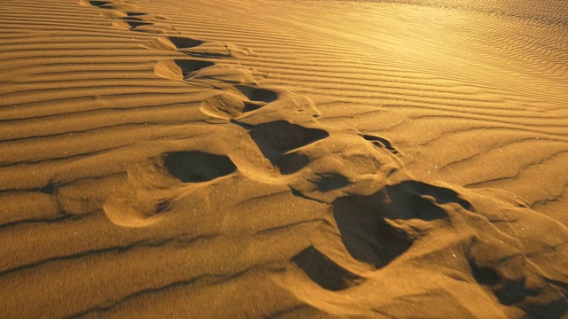 晚上在沙漠的沙丘上留下脚印。替身拍摄,4 k视频下载