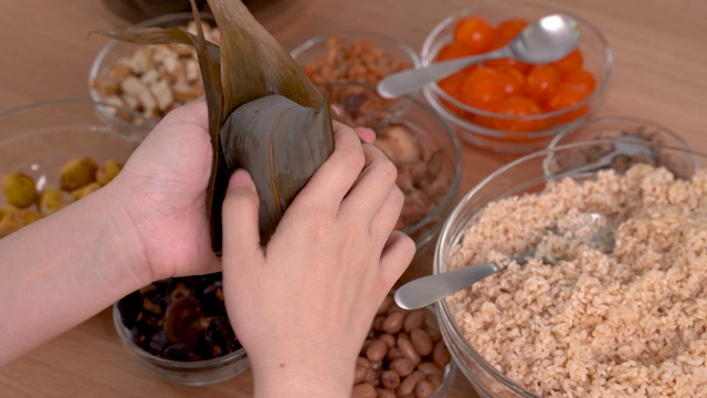制作粽子——家庭准备食物配料的粽子一起制作在家里的木桌上庆祝端午节，近距离，生活方式。视频素材