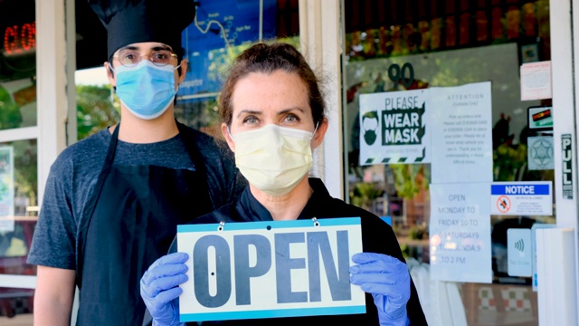厨师快餐店和成熟的女性老板戴着面具举着开放标志视频下载