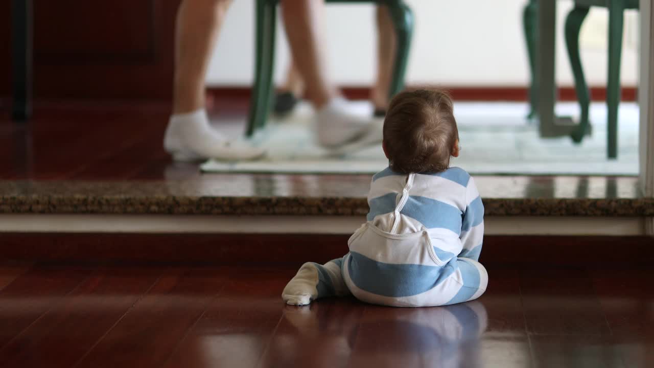 婴儿在家里的硬木地板上爬行，并伸手去够电源插座视频素材
