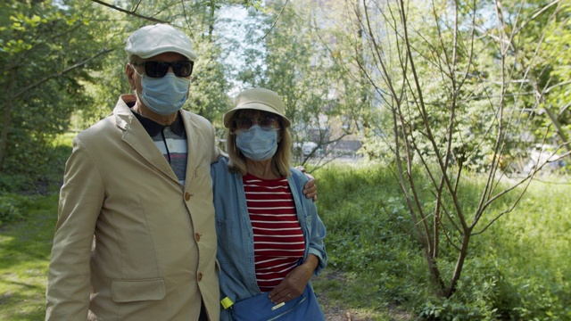 2019冠状病毒病大流行期间，一对老年夫妇在公园散步视频素材
