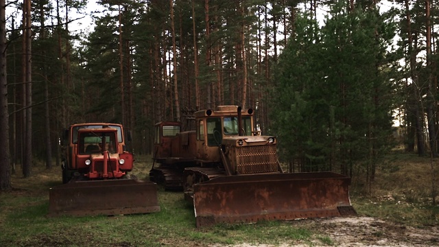 三辆生锈的废弃履带式拖拉机和巨大的装载机桶视频素材