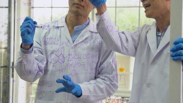 科学家在透明板上画分子结构和写分子式，摇摄视频下载