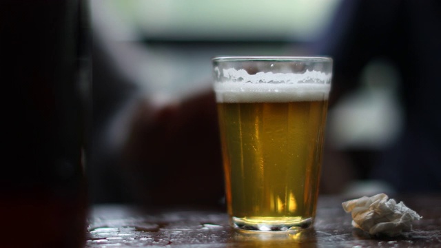 喝酒精饮料的人在酒吧的桌子上喝啤酒视频素材