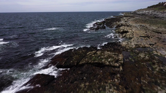 无人机拍摄到海浪撞击岩石海岸的画面视频下载