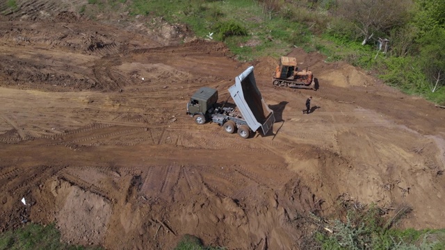高空拍摄另一工地的自卸车地点。靠近推土机碾平的地面。4 k。视频素材