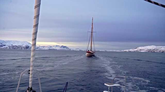 大海和帆船上的日出，背景是白雪覆盖的山脉视频下载