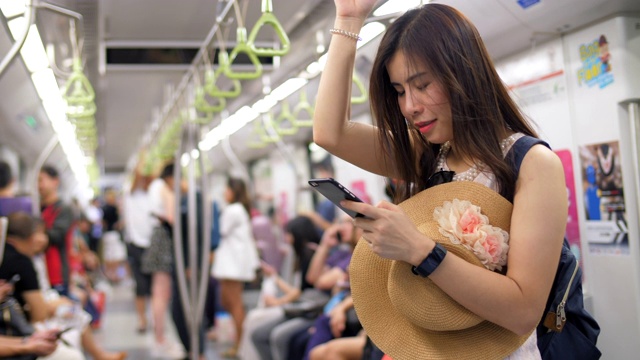 一名年轻女子在公共交通工具上使用智能手机视频素材