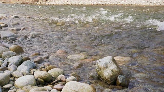 阳光明媚的春日，浅河在岩石上流淌视频素材