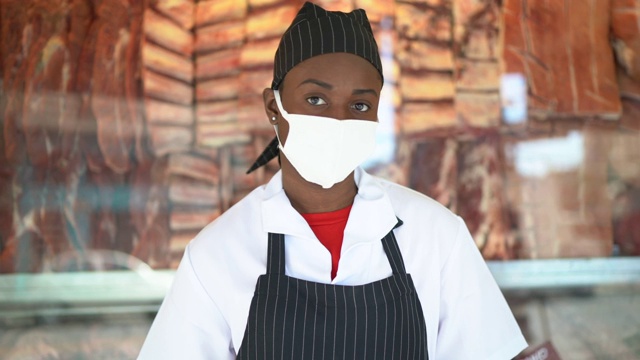 在肉店工作的女屠夫的肖像——带着面具视频素材