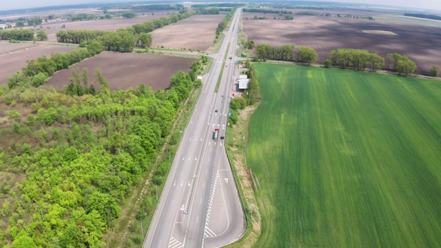 鸟瞰图绿色田野之间的公路在春天。视频素材