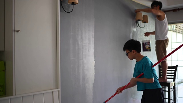 亚裔华人家庭成员帮父亲粉刷房子视频素材