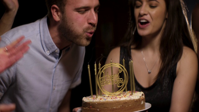 年轻人吹灭生日蛋糕上的蜡烛视频下载