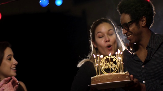 年轻女子吹灭生日蛋糕上的蜡烛2视频素材