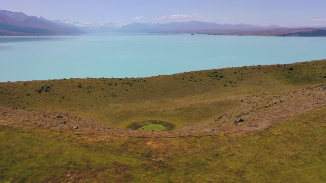 在阳光明媚的一天，无人机飞过山丘和山脉-普卡基湖，新西兰视频素材