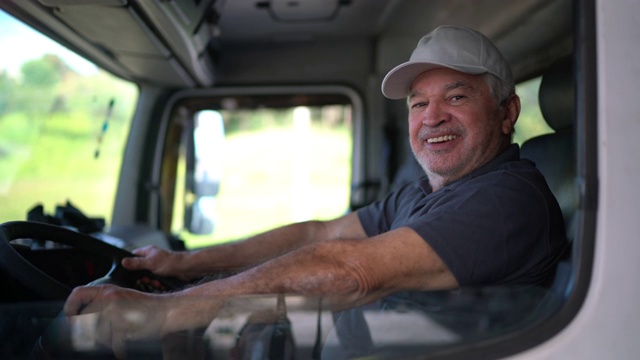一位年长的男性卡车司机坐在驾驶室里视频下载