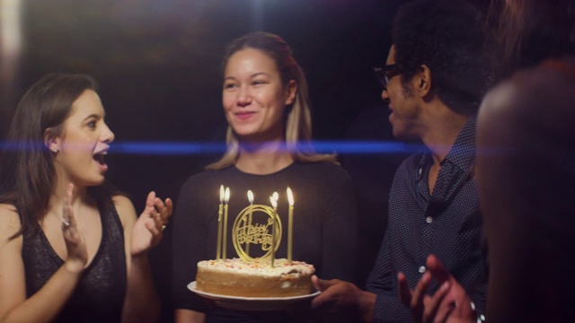 快乐女人吹灭生日蛋糕蜡烛视频素材