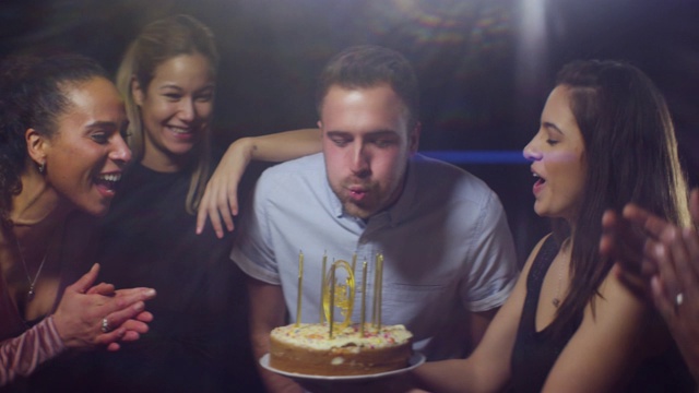 男人和朋友吹灭生日蛋糕蜡烛视频素材