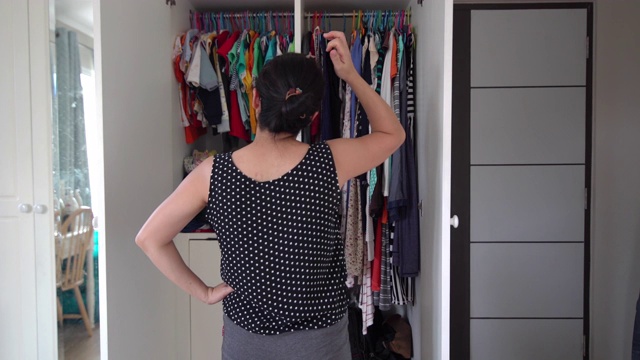 亚洲女人打开衣柜和寻找布料的新对齐视频下载