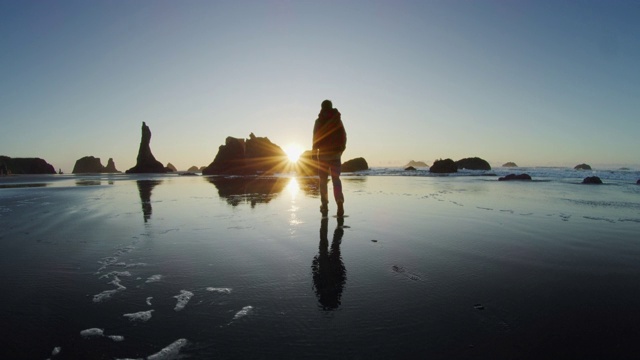 日落时分，一名中年男子在俄勒冈州的海滩上徒步旅行视频素材