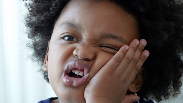 非裔美国小男孩在吃饼干时牙痛视频下载