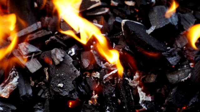 烧烤架上燃烧煤炭的特写镜头。煤开始燃烧了。烹饪食物篝火。前视图。视频素材