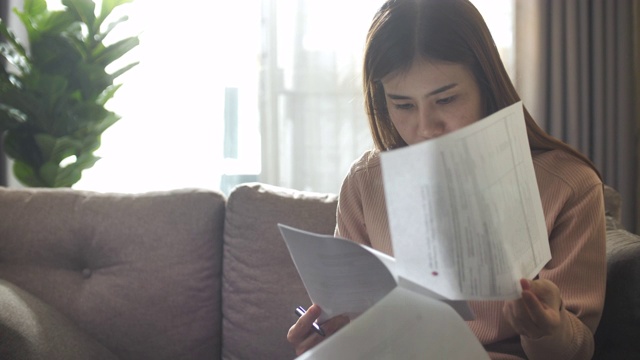 亚洲妇女在家里阅读文件视频素材
