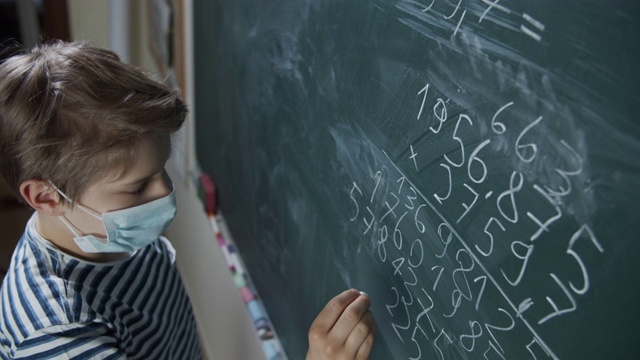 COVID-19大流行期间，可爱的小男孩在上数学课视频素材